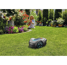 Scéna s robotickou sekačkou na zeleném trávníku v zahradě.