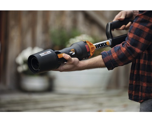 Osoba drží fukar na listí značky WORX.