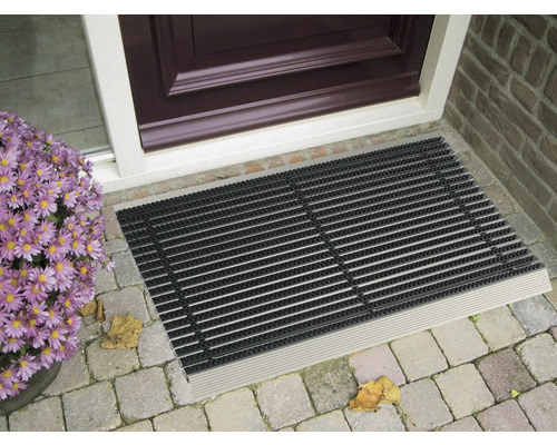 Čisticí rohožka před vchodovými dveřmi s květinami