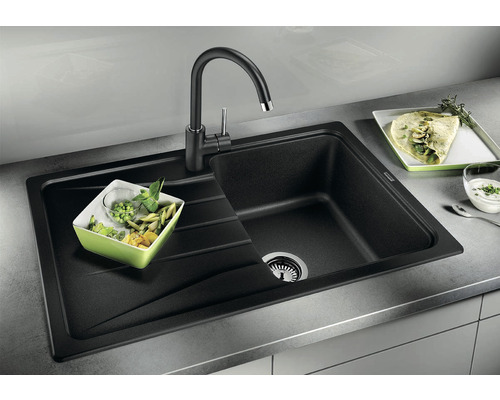 Černý kuchyňský dřez s odkapávací plochou a odpovídající baterií