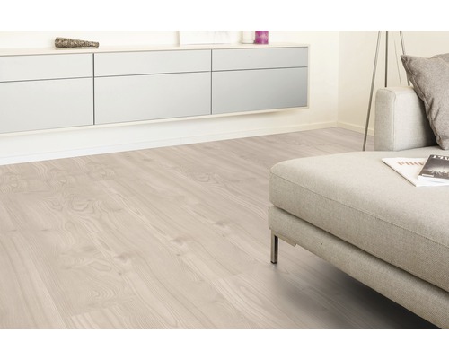 Světlá laminátová podlaha v obývacím pokoji s pohovkou a příborníkem
