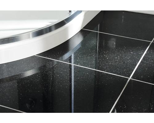 Detailní záběr dlaždic a sprchové vaničky v koupelně.