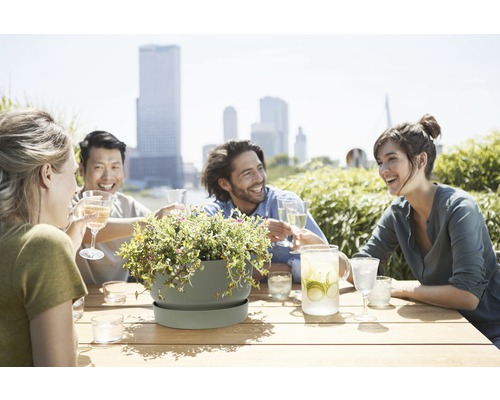 Scéna s lidmi u stolu s nápoji a květináčem s květinami