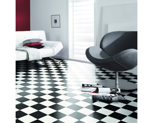 Světlá místnost s vinylovou podlahou se šachovnicovým vzorem, pohovkou a křeslem