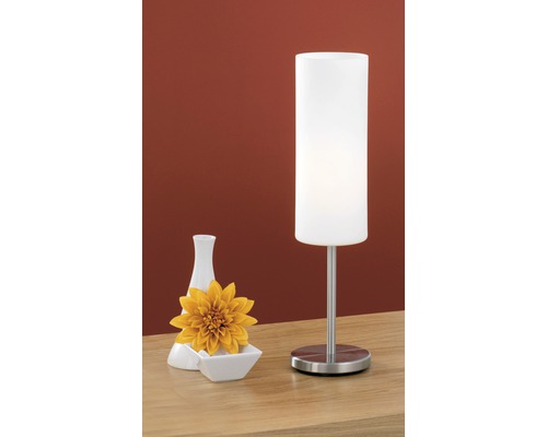 Dekorativní stolní lampa s vázou a květinou na stole