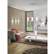 Obývací pokoj s pohovkou, kobercem, konferenčním stolkem a různými lampami pro osvětlení místnosti.