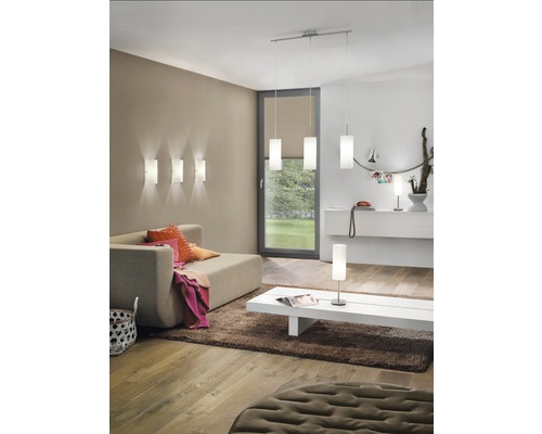 Obývací pokoj s pohovkou, kobercem, konferenčním stolkem a různými lampami pro osvětlení místnosti.