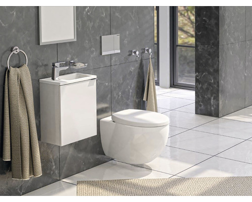 Moderní koupelna se závěsným WC, umyvadlem a ručníky