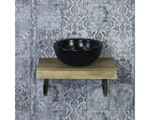 Černé umyvadlo na desce na dřevěné polici s obkládačkami v koupelně