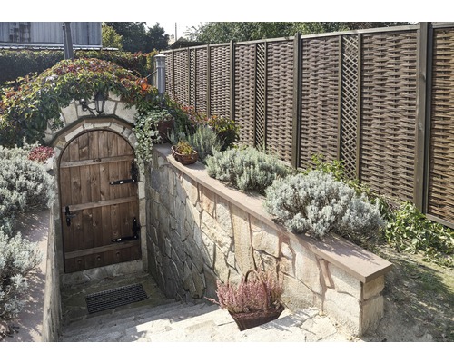 Vnější pohled s zahradní zdí, dřevěnými dveřmi do sklepa a pleteným plotem