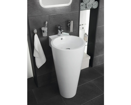 Koupelna s volně stojícím umyvadlem, baterií, držákem na ručníky a doplňky.