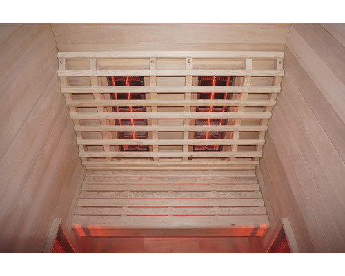 Vnitřní pohled na infračervenou saunu s dřevěným obložením a infračervenými zářiči na stropě