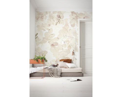 Světlá místnost s fototapetou s motivem listů, matrací a květináčem