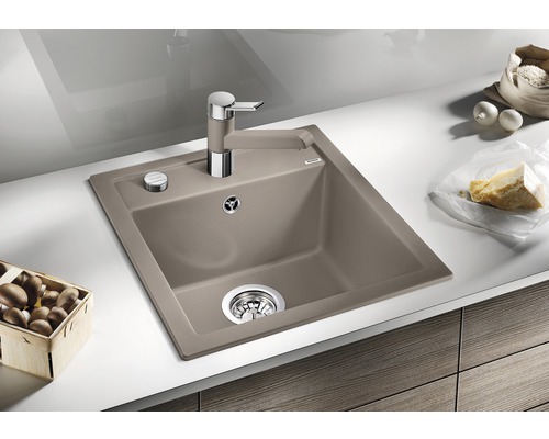 Dřez s odkapávací plochou, kuchyňská baterie a potraviny na kuchyňské lince