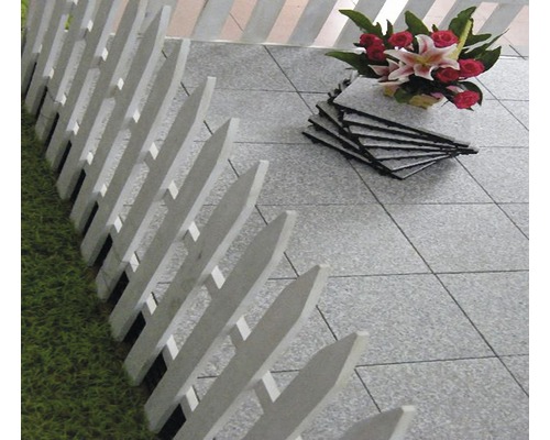 Scéna s šedými terasovými dlaždicemi, bílým plotem a kyticí květin