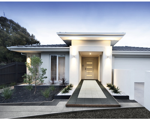 Rodinný dům s dlážděnou cestou ke vchodu a upravenou předzahrádkou