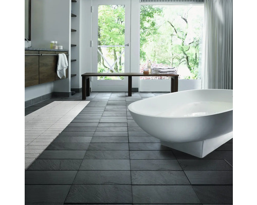 Světlá koupelna s vanou, lavicí a tmavou dlažbou