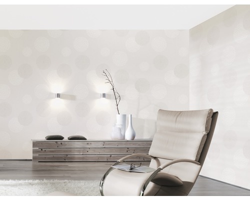 Obývací pokoj s tapetou se vzorem, křeslem a dřevěnou komodou