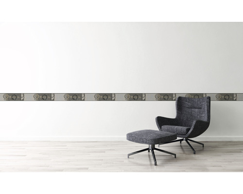 Nástěnná dekorace s bordurou a křeslem ve světlé místnosti.