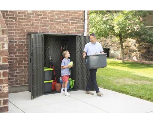 Muž a dítě před kůlnou na nářadí se zahradním nářadím