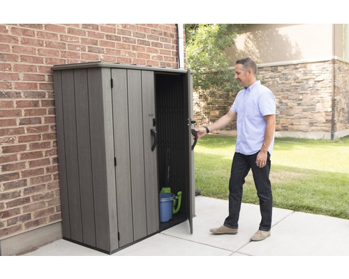 Plastová zahradní skříň s otevřenými dveřmi a osobou před ní