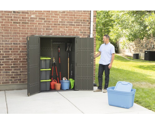 Zahradní scéna s plastovou úložnou skříní na zahradní nářadí a úložné boxy.