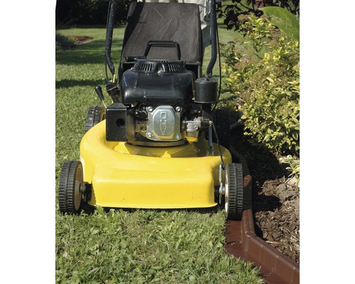 Sekačka na trávu při sekání okrajů trávníku na zahradě