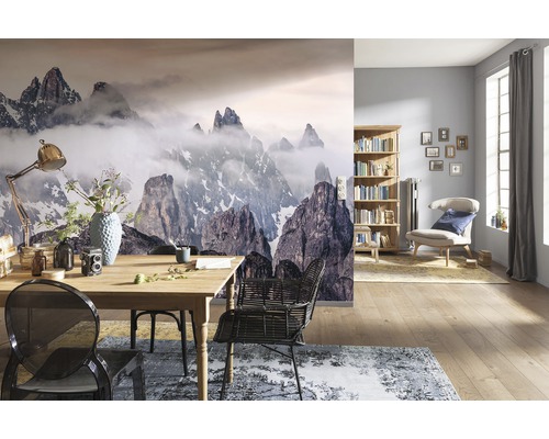 Obývací pokoj s fototapetou horské krajiny, jídelním stolem a knihovnou