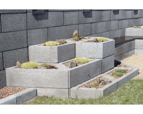 Tvárnice Playstone červená 80 x 35 x 23 cm Naskládané betonové květináče s výsadbou před kamennou zdí