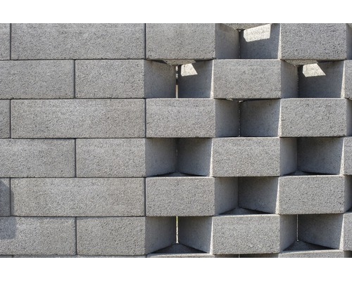Stěna z šedých betonových tvárnic s dekorativními otvory