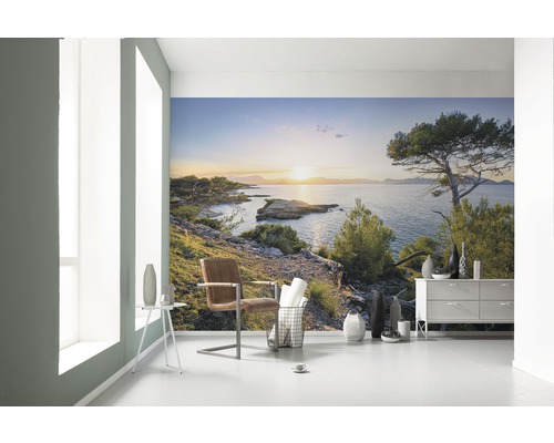 Světlá místnost s fototapetou pobřežní krajiny při západu slunce