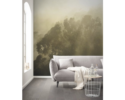 Obývací pokoj s fototapetou lesa v mlze, pohovkou a odkládacím stolkem.