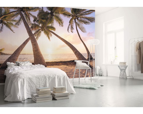 Světlá ložnice s fototapetou zobrazující pláž s palmami.