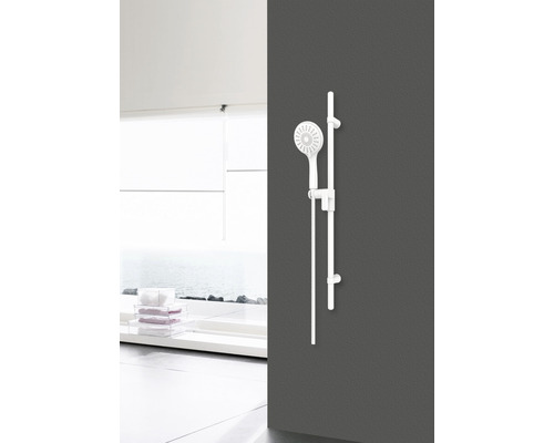 Sprchový set s tyčí namontovanou na stěně v světlé koupelně.