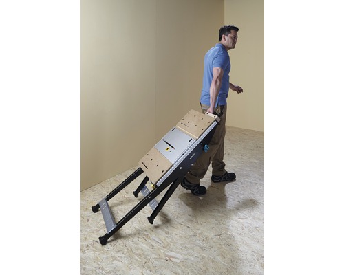 Muž nese složený pracovní stůl