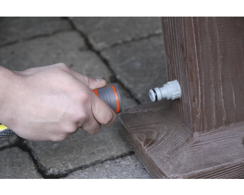 Připojení zahradní hadice k vodovodnímu kohoutku na dřevěném trámu