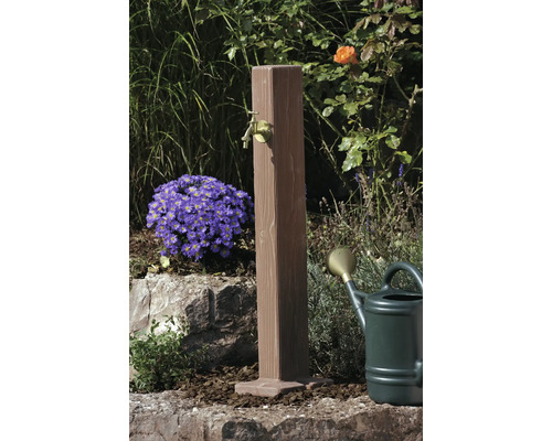 Zahradní scéna s dřevěným vodním sloupkem a mosazným kohoutkem