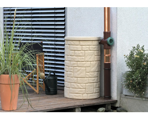 Nádrž na dešťovou vodu se vzhledem kamene vedle svodu na terase