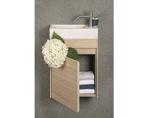 Umyvadlo s mramorovou deskou, baterií a otevřenou dřevěnou skříňkou s ručníky