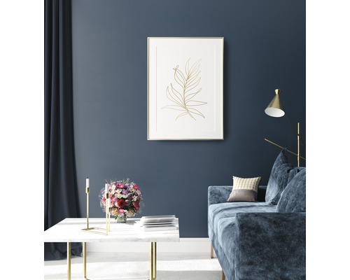 Obývací pokoj s pohovkou, stolem a zarámovaným obrázkem rostliny