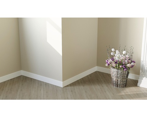 Světle rohový prostor s laminátovou podlahou, bílými podlahovými lištami a květinovou vazbou