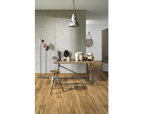 Světlá místnost s dřevěnou podlahou, dílenským stolem a osvětlením