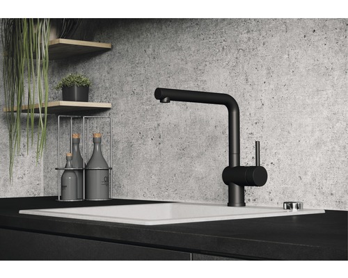 Černá kuchyňská baterie na umyvadle s dekorativními předměty na policích