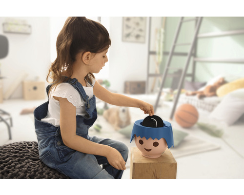 Dívka si hraje s prasátkem v dětském pokoji