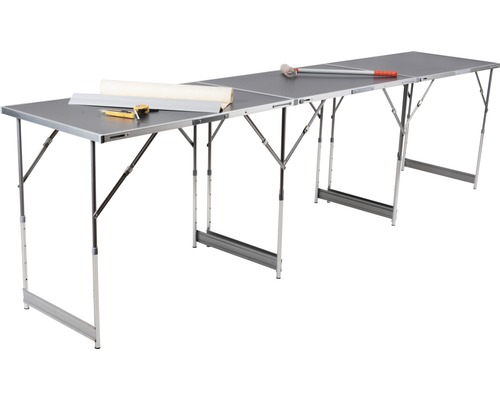 Tapetovací stůl s rolí tapety, řezačkou a svinovacím metrem