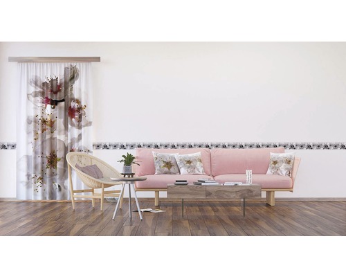 Obývací pokoj se závěsem s květinovým vzorem, bordurou, pohovkou a konferenčním stolkem.