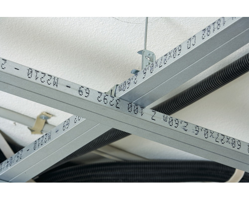 Detailní záběr konstrukce zavěšeného stropu z kovových profilů.