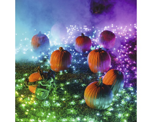Halloweenská scéna s dýněmi a ozdobným osvětlením venku.