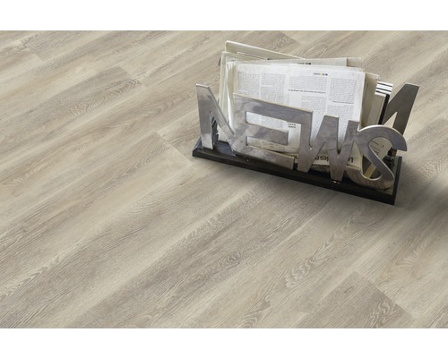 PVC podlaha PRIMETEX 4M 2,0/0,25 COGNAC BLOND (metráž) Světlá laminátová podlaha se vzhledem dřeva a stojanem na noviny.