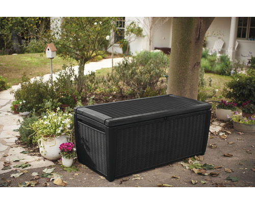 Zahradní scéna s černým zahradním boxem pro venkovní skladování.